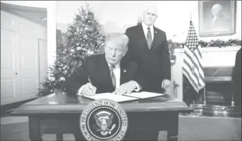  ??  ?? With Vice Pence Mike Pence looking on, U.S. President Donald Trump signs an executive order after he announced the U.S. would Jerusalem as the capital of Israel, in the Diplomatic Reception Room of the White House in Washington, U.S., December 6, 2017....