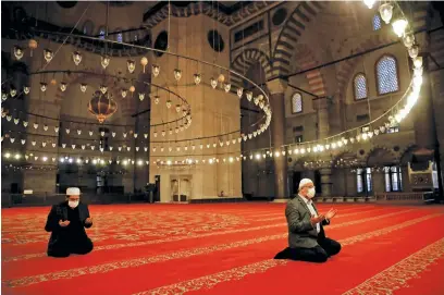  ?? Picture: Reuters ?? Staff at Suleymaniy­e Mosque perform a morning prayer behind closed doors during the first day of Eid and the second day of a four-day curfew, amid the Covid-19 outbreak, in Istanbul, Turkey, yesterday.