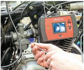  ??  ?? Using a borescope to roughly set the idle screws on the carbs.