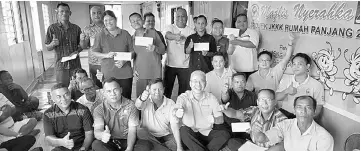  ??  ?? Teng (seated, seventh right) is seen in a photo with longhouse folk at Rumah Bansa.