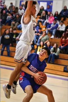  ?? JOHN T. DENNE/For the Taos News ?? Bobcat Lucas Martinez puts on his brakes while going in for a fastbreak layup, and watches as Peñasco’s Demarcus Lopez takes the feint and flies on past.