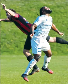  ??  ?? Matthew Gauci goes flying in this contest as Warragul United work tirelessly to find an equaliser against Malvern.