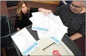  ?? CHARLES KRUPA / AP ?? Deputy Town Clerk Lynne Gagnon, left, of Derry, N.H., unloads test ballots from a storage cart Tuesday as Tina Guilford, Derry town clerk, prepares to load them into the ballot counting machine again while testing the machines ahead of the New Hampshire primary, at the Derry Municipal Center.