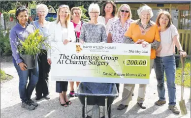  ??  ?? Natalie Perry from David Wilson Homes Kent with members of the Charing Surgery Gardening Group