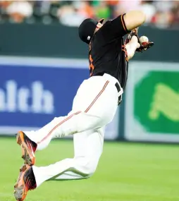  ?? (Reuters) ?? BALTIMORE ORIOLES first baseman Chris Davis dives to make a catch on a ball hit by the Houston Astros’ Carlos Beltran in the sixth inning of Houston’s 8-7 road victory over the Orioles on Friday night at Camden Yards.