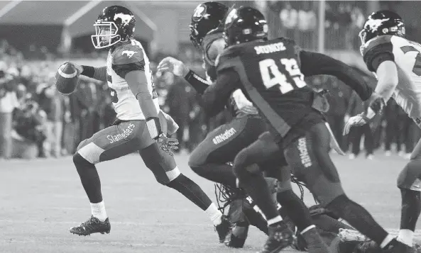  ?? PETER POWER / THE CANADIAN PRESS ?? Stampeders quarterbac­k Andrew Buckley goes wide before being tripped up by a lunging Abdul Kanneh of the Redblacks in last year’s Grey Cup game in Toronto.