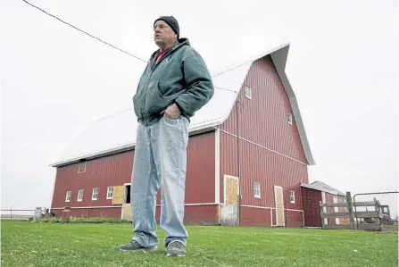  ?? Charlie Neibergall, The Associated Press ?? Morey Hill stands near a barn on his 400-acre farm near Madrid, Iowa. He is looking forward to putting the uncertaint­y of recent years behind him.