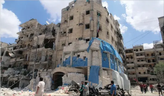  ?? Pictures: Reuters ?? SHOCK: People inspect the damage at al-Quds hospital after it was hit by air strikes in a rebel-held area of Syria’s Aleppo.