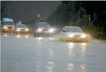  ?? MARTIN DE RUYTER/NELSON MAIL ?? Cars drive through floods in 2006 at Ruby Bay.