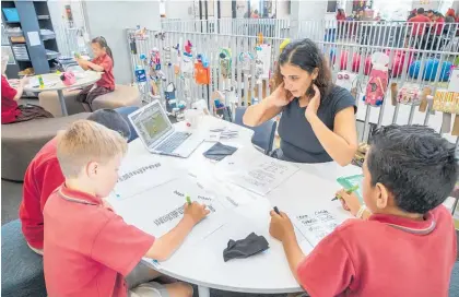  ?? Photo / Peter Meecham ?? Teacher aide Silva Mezel works with students on vocabulary in the modern learning environmen­t at The Gardens School in Manurewa.