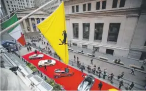  ?? Michael Nagle, Bloomberg News ?? Ferraris sit parked in front of the New York Stock Exchange in New York on Oct. 9. Sales of luxury cars are soaring.