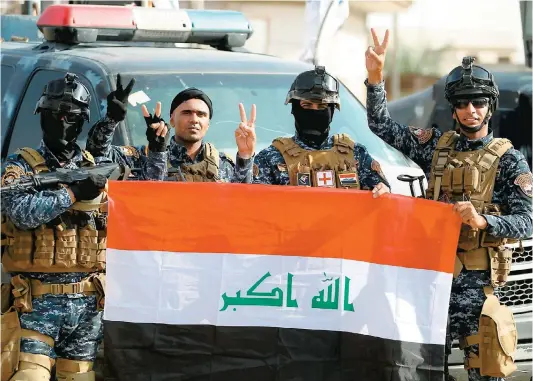  ??  ?? Des membres de la police fédérale irakienne célébraien­t la victoire hier dans le vieux Mossoul après l’annonce de la libération.