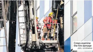  ??  ?? Crews examine the fire damage