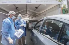  ?? AFP ?? Egyptian health workers collect samples at a drive-through coronaviru­stesting center at the Ain Shams University in Cairo on Monday.