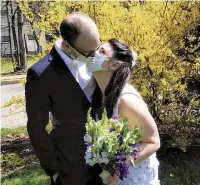  ??  ?? Newlyweds Danielle Cartaxo and Ryan Cignarella celebrated with a kiss while wearing masks after getting married in West Orange, N.J.