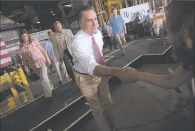  ?? EVAN VUCCI AP PHOTO ?? Republican presidenti­al candidate Mitt Romney shakes hands during a campaign stop Thursday at Seilkop Industries in Cincinnati. Romney and President Barack Obama dueled from opposite ends of a state vital to their November chances, framing the election...