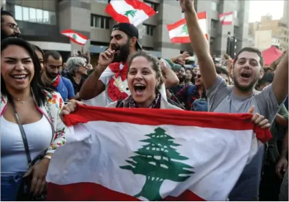  ??  ?? Demonstran­ter i Libanons hovedstad, Beirut, jubler over, at deres premiermin­ister, Saad Hariri, og hans regering tirsdag trådte tilbage.
Foto: Patrick Baz/AFP