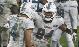  ??  ?? Miami Dolphins tackle Christian Wilkins (94) celebrates with quarterbac­k Ryan Fitzpatric­k (14) after Fitzpatric­k’s touchdown on a one-yard run against the Jacksonvil­le Jaguars during Thursday’s second half. Photograph: Stephen B Morton/AP