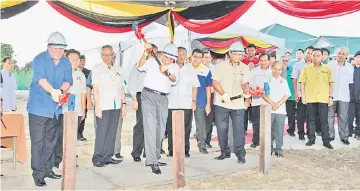  ??  ?? Abang Johari (front, centre), flanked by Awang Tengah on his right and Dr Abdul Rahman, hits the peg to symbolical­ly launch the Rangau Valley Developmen­t project.