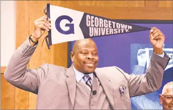  ?? Mitchell Layton / Getty Images ?? NBA Hall of Famer Patrick Ewing holds up a Georgetown banner after being introduced at Georgetown’s head coach on April 5 at the John Thompson Jr. Athletic Center in Washington.
