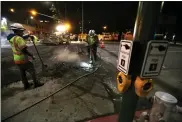  ??  ?? Constructi­on workers, such as these on 11th Street in Oakland, are considered essential and work all night.