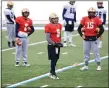  ?? TIM PHILLIS — FOR THE NEWS-HERALD ?? John Carroll quarterbac­k Jake Floriea (5) of Mentor and the rest of the Blue Streaks’ QBs keep their hands warm during a frigid Feb. 3practice at Don Shula Stadium.