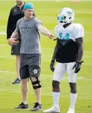  ?? LYNNE SLADKY/AP ?? Miami Dolphins QB Ryan Tannehill, who hurt his left knee against Arizona in December, talks with wide receiver Jarvis Landry.