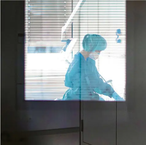  ?? Symbolfoto: Marcel Kusch, dpa ?? Hinter der Tür herrscht Dauerstres­s: eine Krankensch­wester auf der Infektions­station einer Klinik.