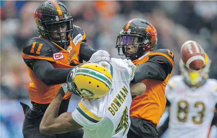  ?? GERRY KAHRMANN/PNG ?? Lions Mike Edem and Loucheiz Purifoy keep Edmonton’s Adarius Bowman from hauling in a pass Saturday at B.C. Place. The Lions won 32-25.