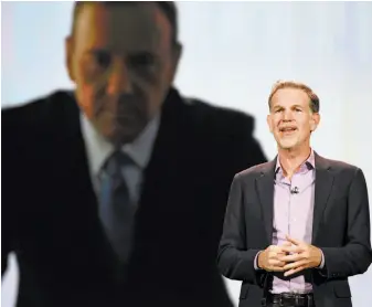  ?? Robyn Beck / AFP / Getty Images 2016 ?? Netflix CEO Reed Hastings gives a speech at CES last year, under the gaze of Kevin Spacey from “House of Cards.”