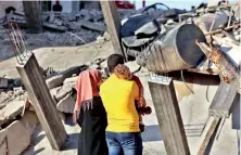  ??  ?? Palestinia­ns inspect the rubble of buildings, destroyed by Israeli strikes, in Beit Lahia in the northern Gaza Strip (AFP)