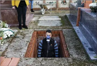  ?? BERNAT ARMANGUE — THE ASSOCIATED PRESS ?? An undertaker prepares a grave in Zarza de Tajo, central Spain, on Wednesday.