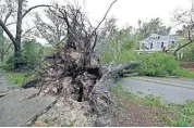  ?? [AP PHOTO] ?? A tree uprooted by strong winds lies across a street Friday in Wilmington, N.C., after Hurricane Florence made landfall.