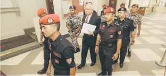  ?? — Malay Mail photo ?? Najib is escorted by Prisons Department officers at the court.
