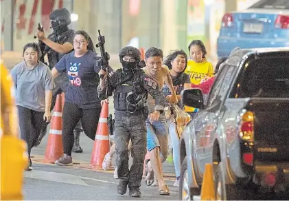  ?? AFP ?? Corridas. En medio del tiroteo, la policía evacuó a la gente que se hallaba cerca del shopping.