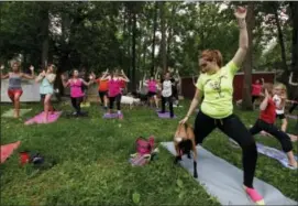  ??  ?? Casey Chaffin pets a goat as part of a goat yoga session in Burlington, Wis.