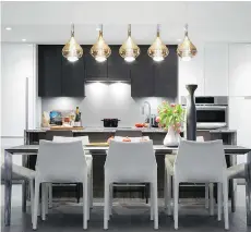  ??  ?? The kitchen has wood veneer and contempora­ry high-gloss white acrylic cabinets.