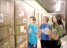  ?? LYNN KUTTER ENTERPRISE-LEADER ?? Colton Miller, Erik Skogen and Lena Skogen, all of Cane Hill, walk through a traveling exhibit at Historic Cane Hill Museum called The Great War: Arkansas in World War I. The students are homeschool­ed and were having a history lesson that day.