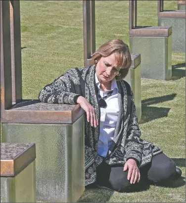  ??  ?? Lynne Gist sits Wednesday next to her sister’s memorial in the Field of Empty Chairs at the Oklahoma City National Memorial and Museum in Oklahoma City. The site is made up of 168 empty chairs representi­ng those who lost their lives, with their name etched in the glass base. Gist’s sister was Karen Gist Carr, 32.
(AP/Sue Ogrocki)