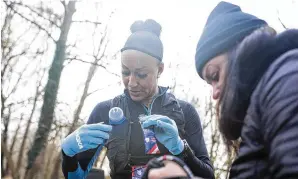  ?? ?? Sika Henry picks up food from her mother, Regina Henry, along the path of the JFK 50 Mile ultramarat­hon in Antietam, Md., on Nov. 20, her first ultramarat­hon and her final race of the year.