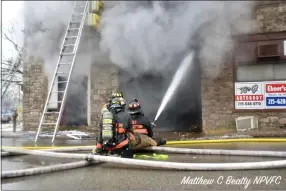  ?? PHOTO COURTESY OF MATTHEW B. BEATTY, NORTH PENN VOLUNTEER FIRE COMPANY ?? Firefighte­rs spray water at the building fire Thursday.