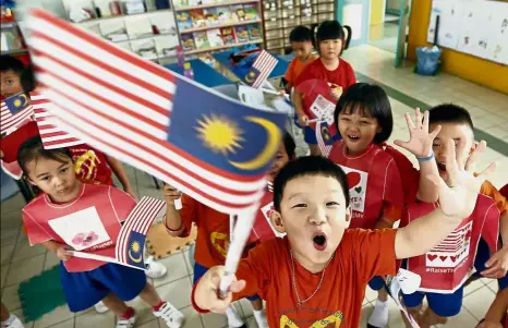  ??  ?? Young patriots: Children of Tadika Padungan waving their self-assembled Jalur Gemilang.