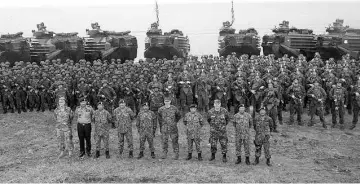  ??  ?? The Malaysian and United States military officers with the participan­ts and assets involved in the four-day amphibious exercise at Kampung Tanduo’s beach.