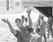  ?? ALEX BRANDON/AP ?? A Haitian aid worker tosses a hygiene kit while unloading a VM-22 Osprey on Saturday at an airport in Jeremie, Haiti. The Aug. 14 quake caused heavy damage.