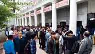  ?? PTI ?? People queue up at an ATM to withdraw cash at CP on Thursday