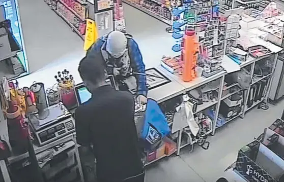  ??  ?? A man wielding a samurai sword robs a Spar Express store in Upper Coomera on Tuesday. Below: The thief drops his sword as he races from the store.