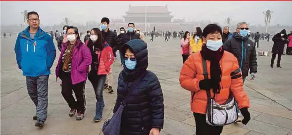  ?? AFP PIC ?? People wearing masks at Tiananmen Square in Beijing. Carbon trading is something that even the developed West struggles to put in place, but China is paving the way.