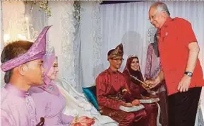  ?? ASYRAF SAWAL
PIC BY MUHD ?? Datuk Seri Najib Razak with the happy couples at their wedding ceremony in Kampung Panchor, Pekan, yesterday.