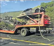  ??  ?? DEVASTATIN­G LOSS: High-performanc­e cars being transporte­d yesterday after the weekend’s Jaguar Simola Hillclimb in Knysna are gutted by fire