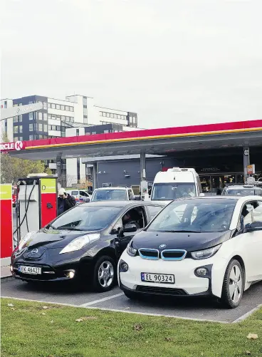  ?? KYRRE LIEN / BLOOMBERG ?? Electric vehicles recharge at an Alimentati­on Couche-Tard Circle K station in Oslo. OPEC sees oil demand peaking in the late 2030s if electric vehicle sales boom, and also forecasts a decline in oil demand if ride-hailing and car-sharing also increas.